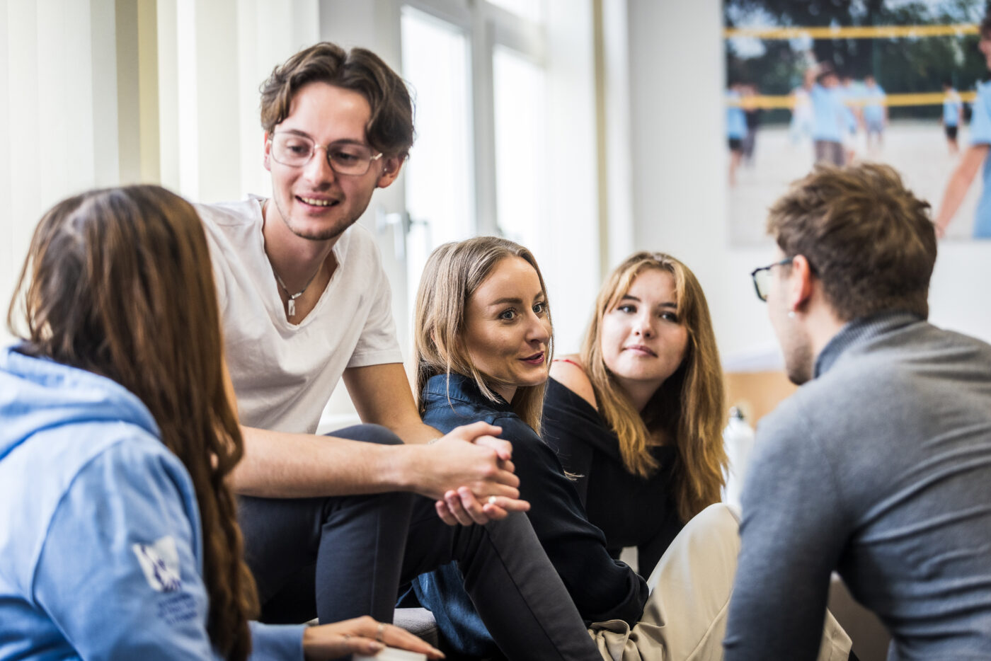 A small group of students sitting together in a bright, modern campus setting, engaged in an active discussion. The atmosphere feels collaborative and open, reflecting the interactive learning environment at UNYP. The students appear to be exchanging ideas and listening attentively, which aligns well with the approach of the School of Business—where discussion, teamwork, and real-world problem solving are central to the classroom experience. The setting suggests a dynamic academic environment that supports peer learning, leadership development, and practical business thinking.
