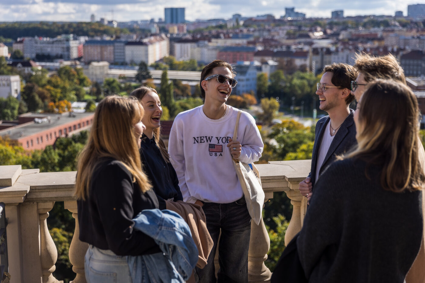 university students in Prague talking outdoors with city view during psychology studies