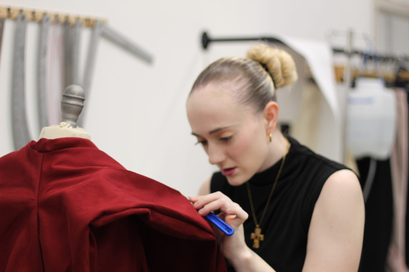 Student refining a garment during a fashion design workshop.